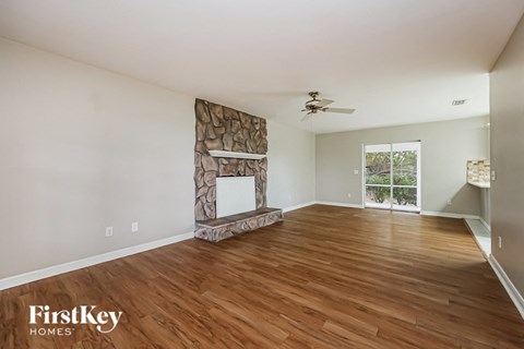 a living room with a fireplace and wooden floors