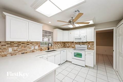 a white kitchen with white appliances and white cabinets