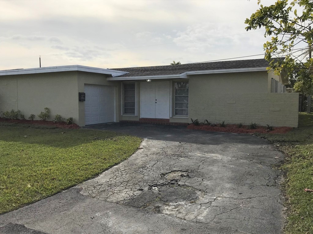 A house with a cracked driveway and a white garage door.