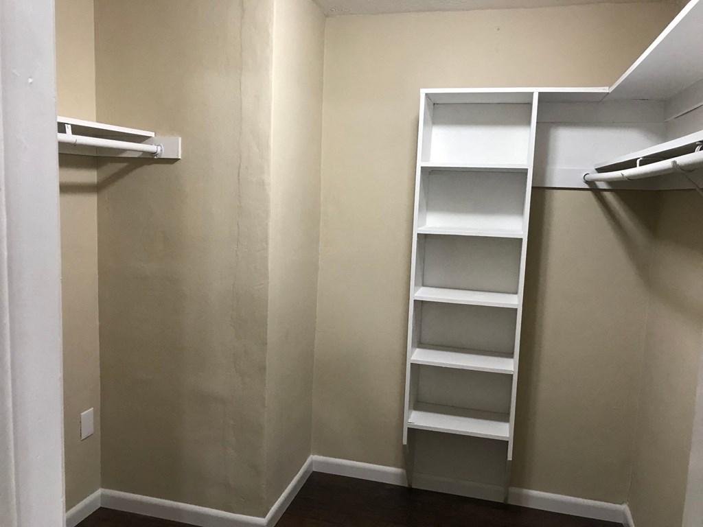 A walk-in closet with shelves and drawers.