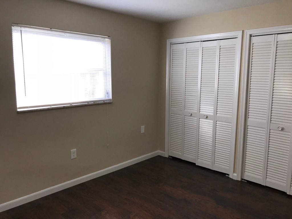 A room with a window and two closets.