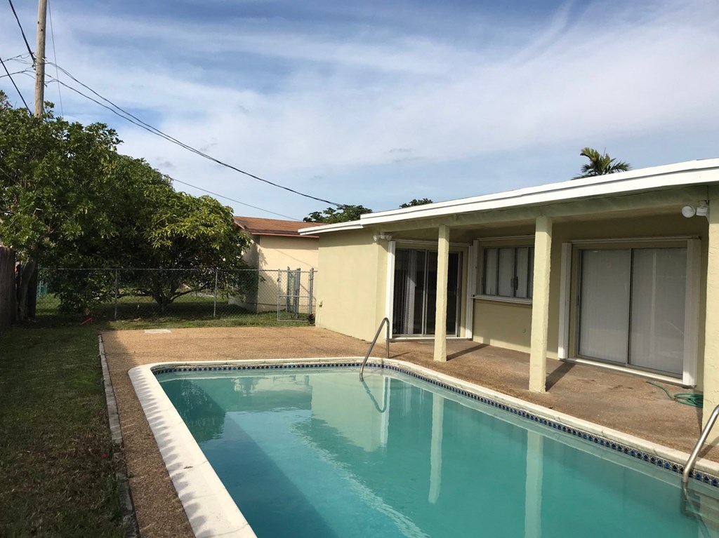 A small residential pool in front of a house.