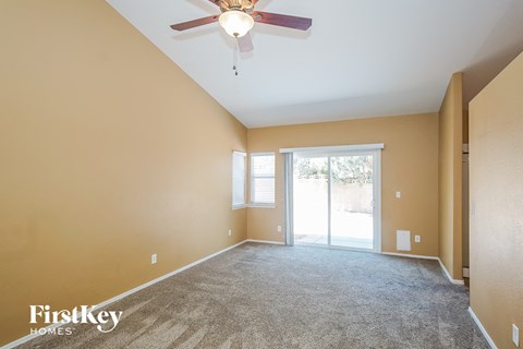 a living room with carpet and a ceiling fan