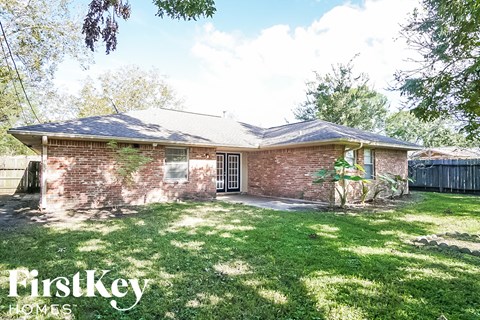 the front of a brick house with a yard and grass