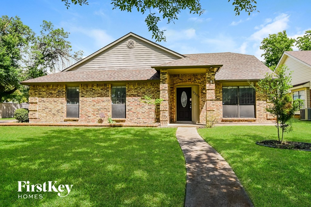 A brick house with a tree in front of it.