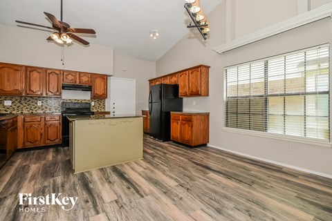 A kitchen with wooden cabinets and a black refrigerator.