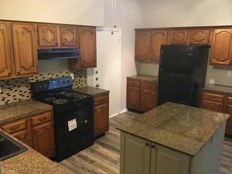 a kitchen with black appliances and granite counter tops