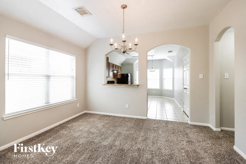 an empty living room with carpet and a large window