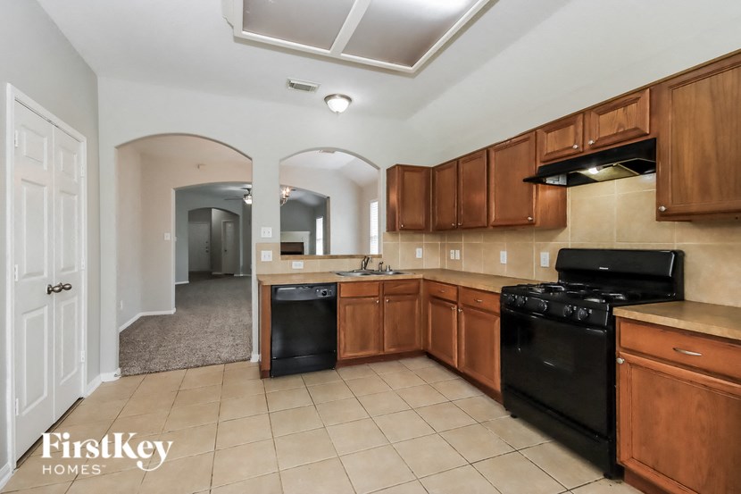 a large kitchen with black appliances and wooden cabinets
