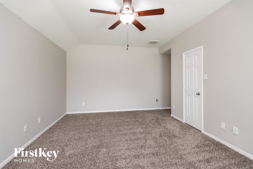 an empty room with a ceiling fan and a white door