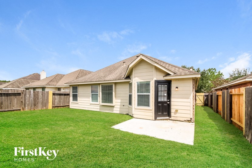 a backyard with a house and a yard and a fence