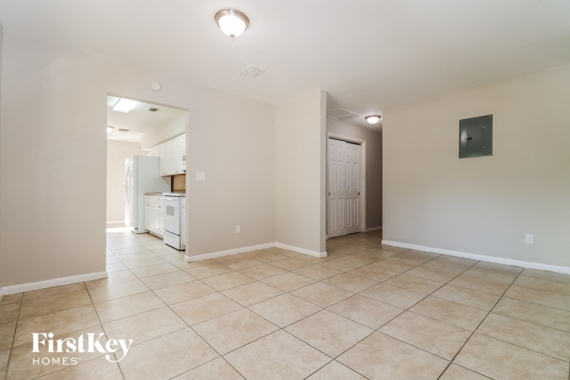 an empty kitchen and living room with tiled flooring
