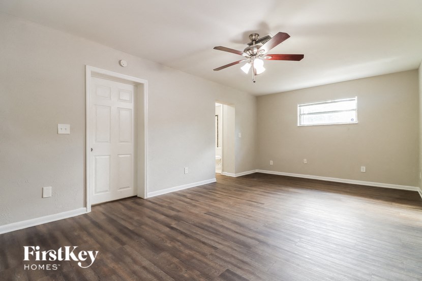 the living room of an empty house with a ceiling fan