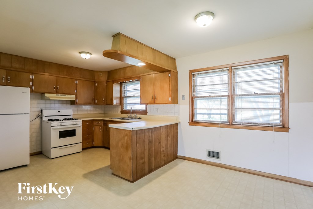 A kitchen with wooden cabinets and a white refrigerator.