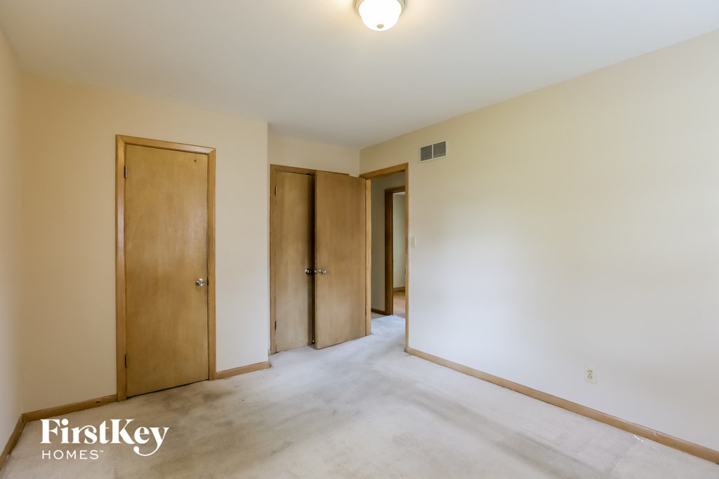 A room with two doors and a wall-mounted light fixture.