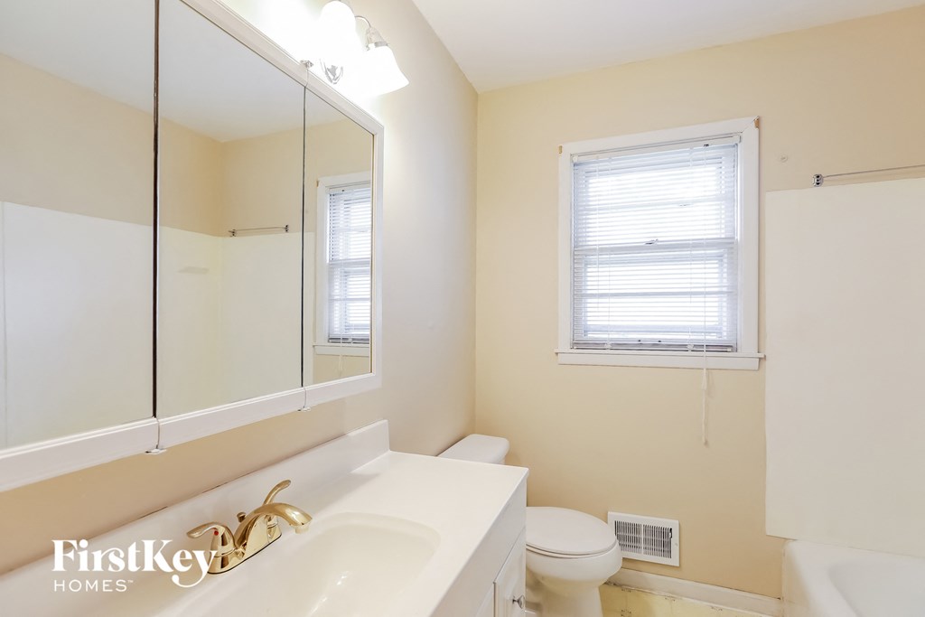 A bathroom with a white sink and a toilet.