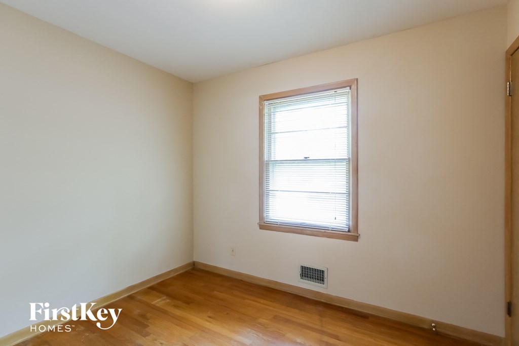 A room with a window and wooden floors.