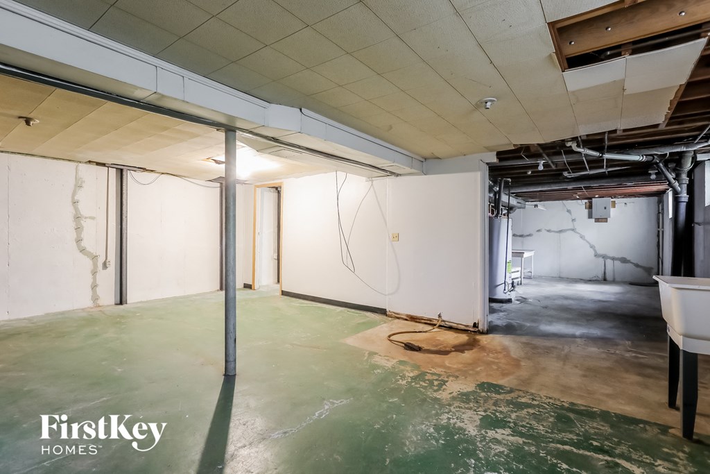 A room with a green floor and white walls is under construction.