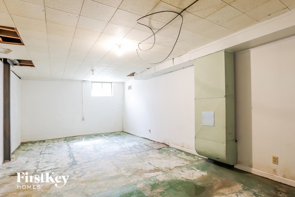 A room with a green floor and a white wall with a door.