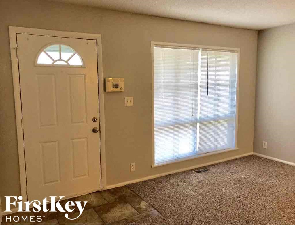 A room with a door, window, and a carpet.