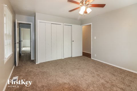 a bedroom with a carpeted floor and a ceiling fan
