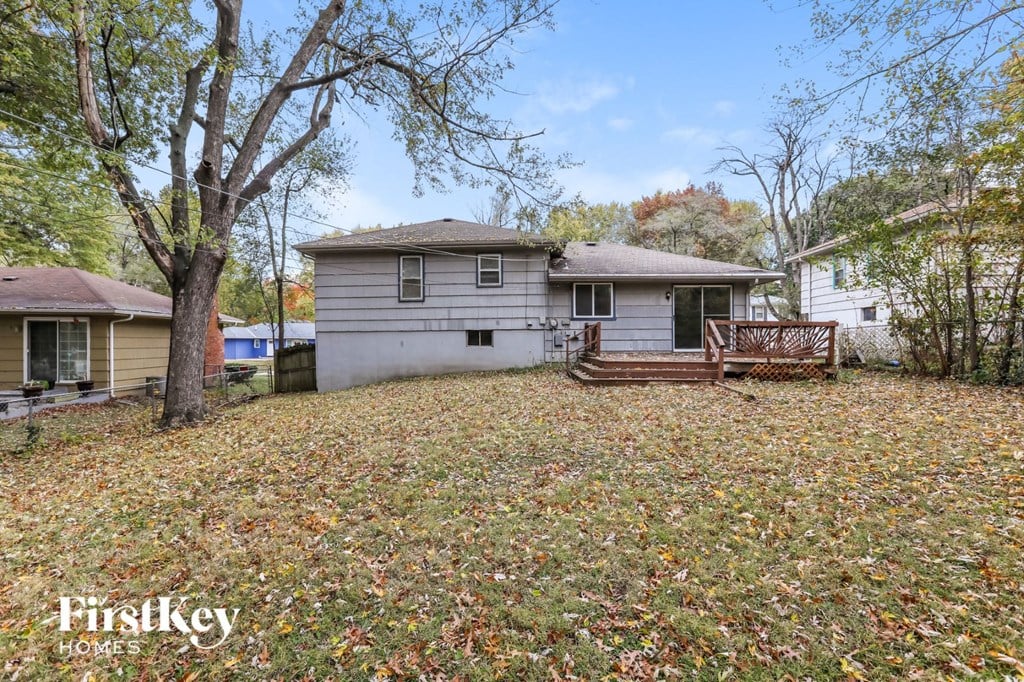 a small white house with a yard and a deck