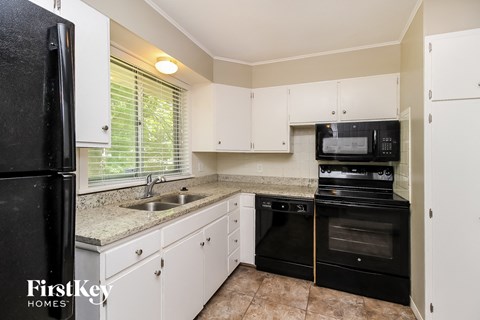 a kitchen with black appliances and white cabinets