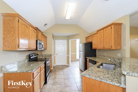 A kitchen with wooden cabinets and granite countertops.