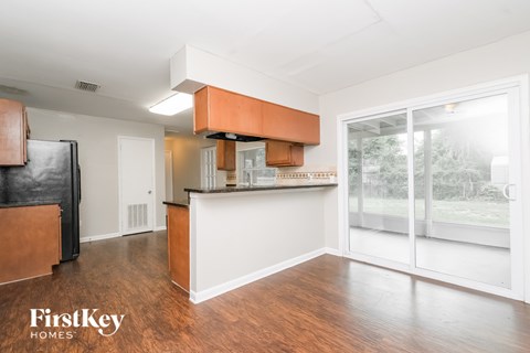 A kitchen with a refrigerator, cabinets, and a countertop is shown in a real estate listing.