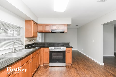 A kitchen with wooden cabinets and a black countertop.