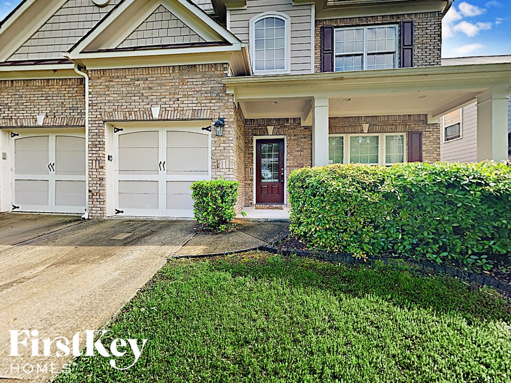 the front of a brick house with white doors