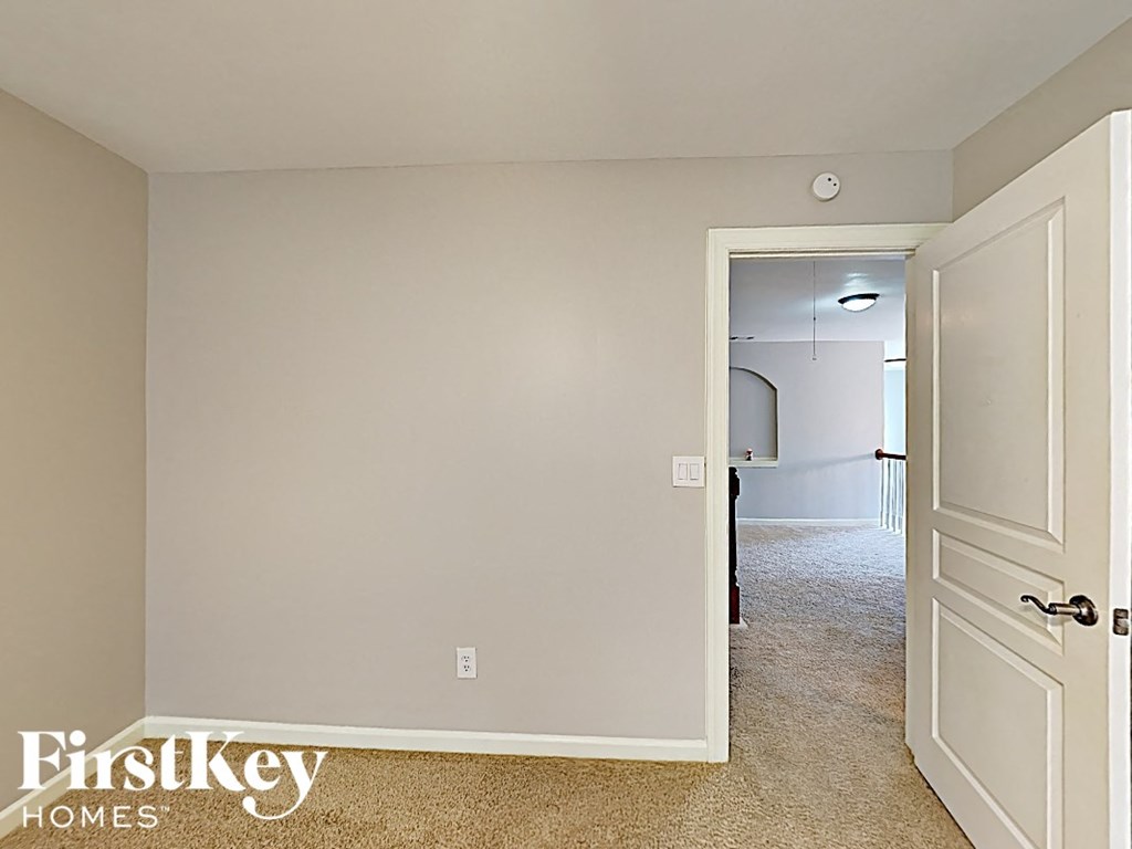 a bedroom with an open door and a hallway to a closet