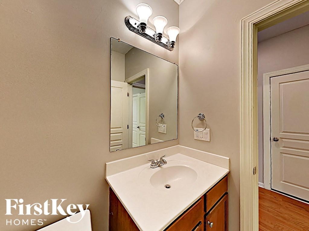 a bathroom with a sink and a mirror and a door