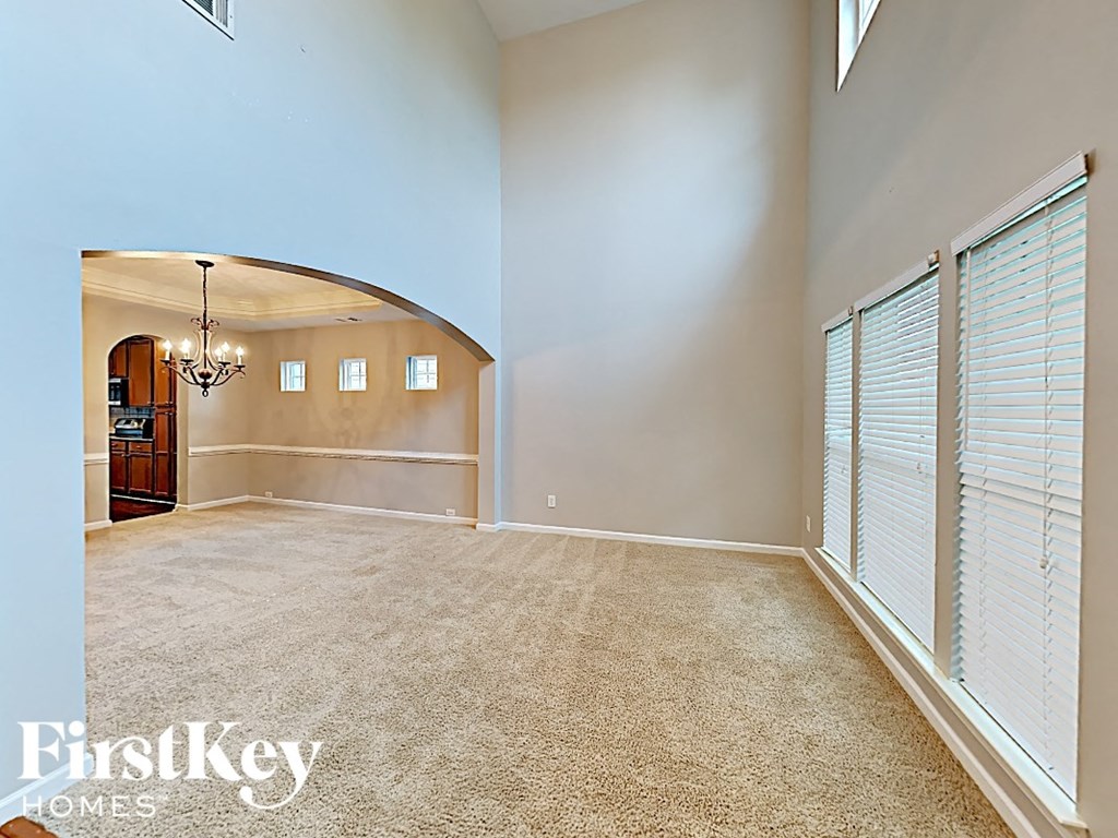 an empty living room with blinds on the window