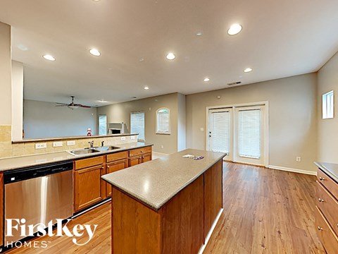 an open kitchen with wood flooring and stainless steel counter tops