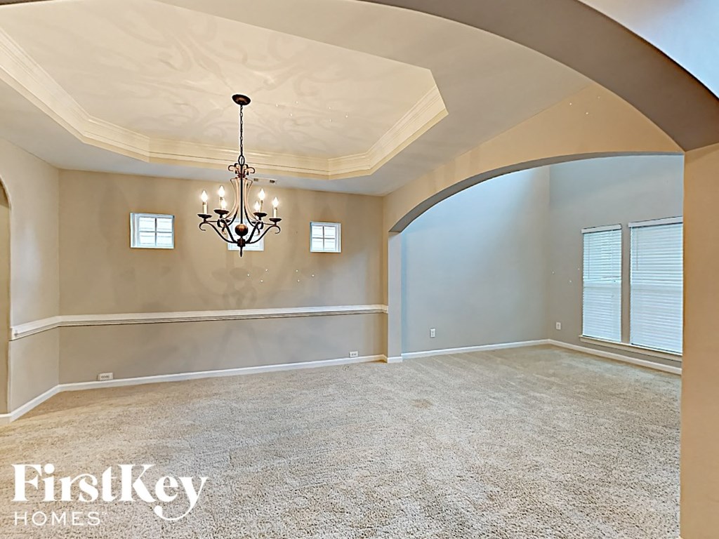 an empty living room with a chandelier