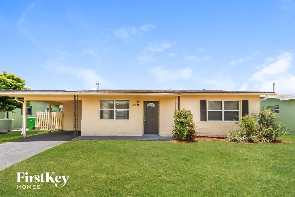 A beige house with a black door and windows is for sale.