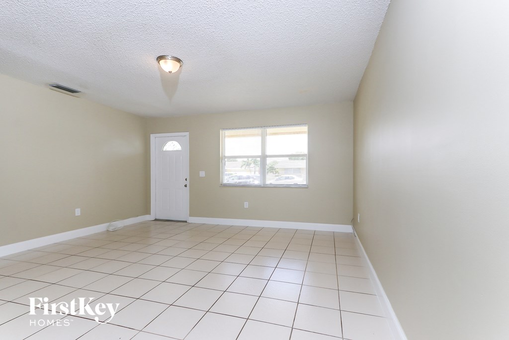 A room with a white door and a window with white walls.