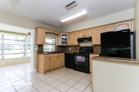 A kitchen with black appliances and wooden cabinets.
