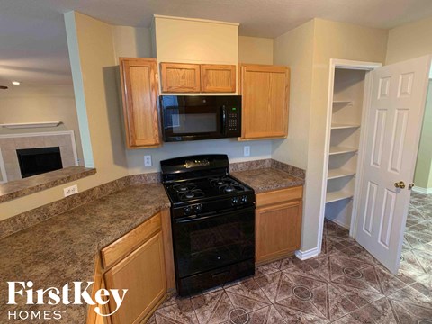 a kitchen with a stove and microwave and wooden cabinets