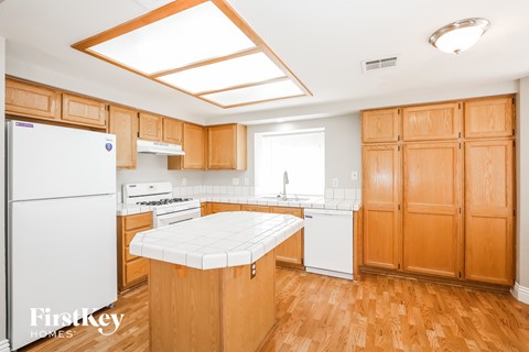 A kitchen with wooden cabinets and a white fridge.
