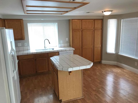 A kitchen with wooden cabinets and a white island.