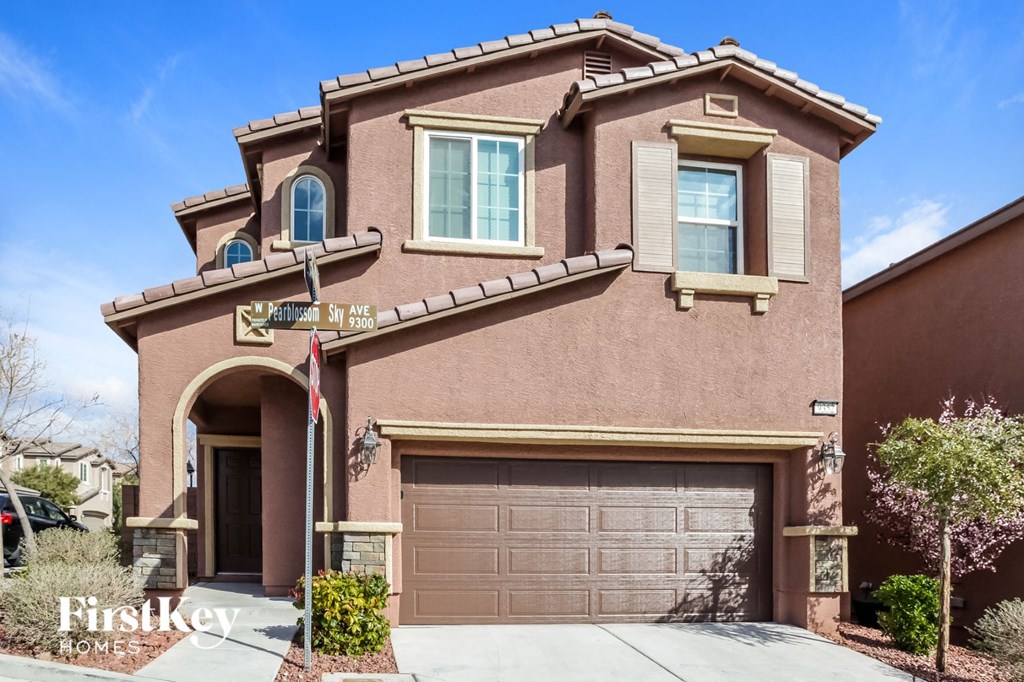 A house with a brown garage door and a sign that says "Firstkey Home".