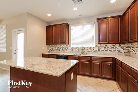 A kitchen with brown cabinets and a granite countertop.
