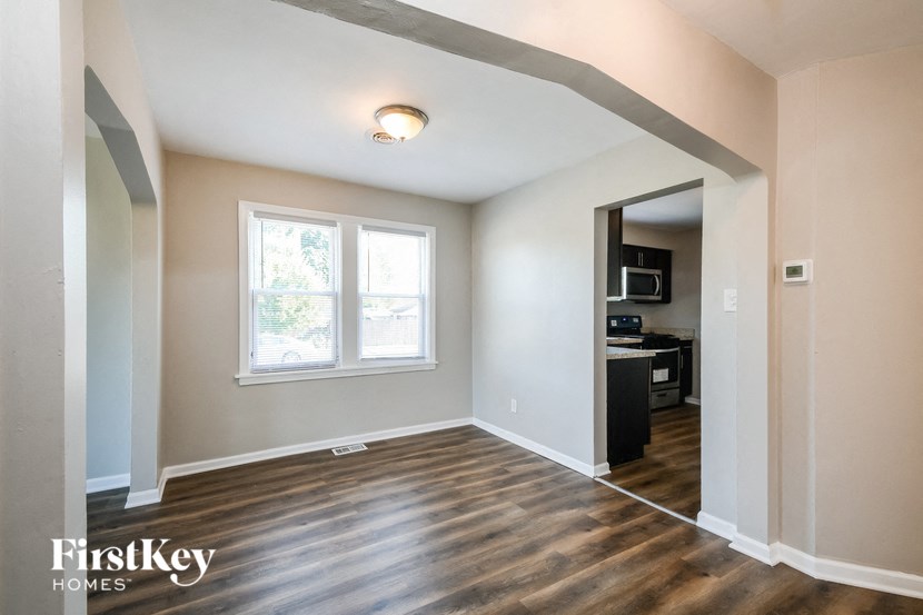 an empty living room with wood flooring and a window