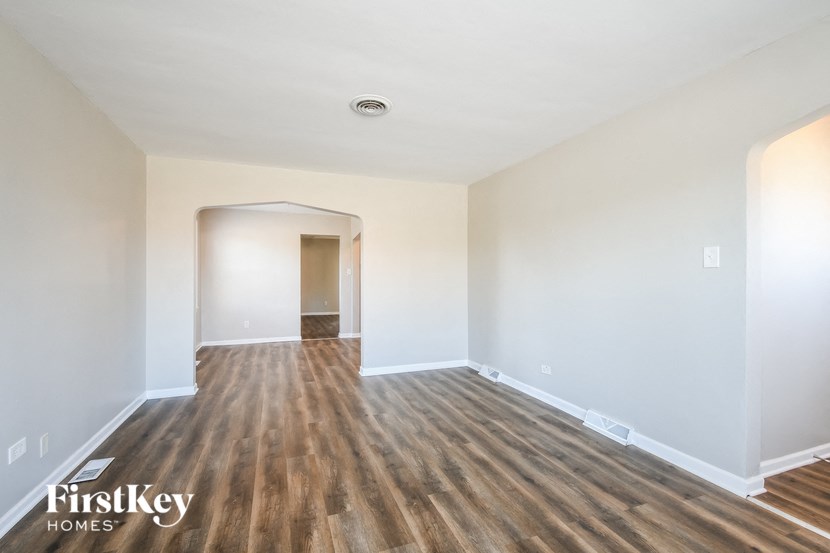 an empty living room with white walls and wood flooring