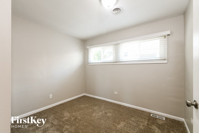 a empty room with carpet and a window