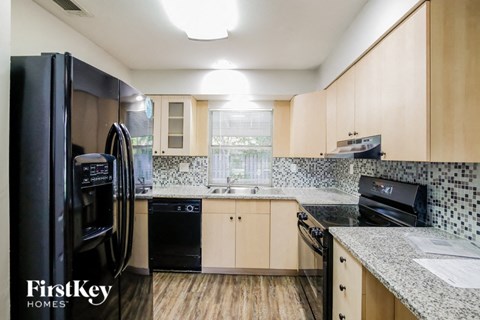 a kitchen with black appliances and granite counter tops