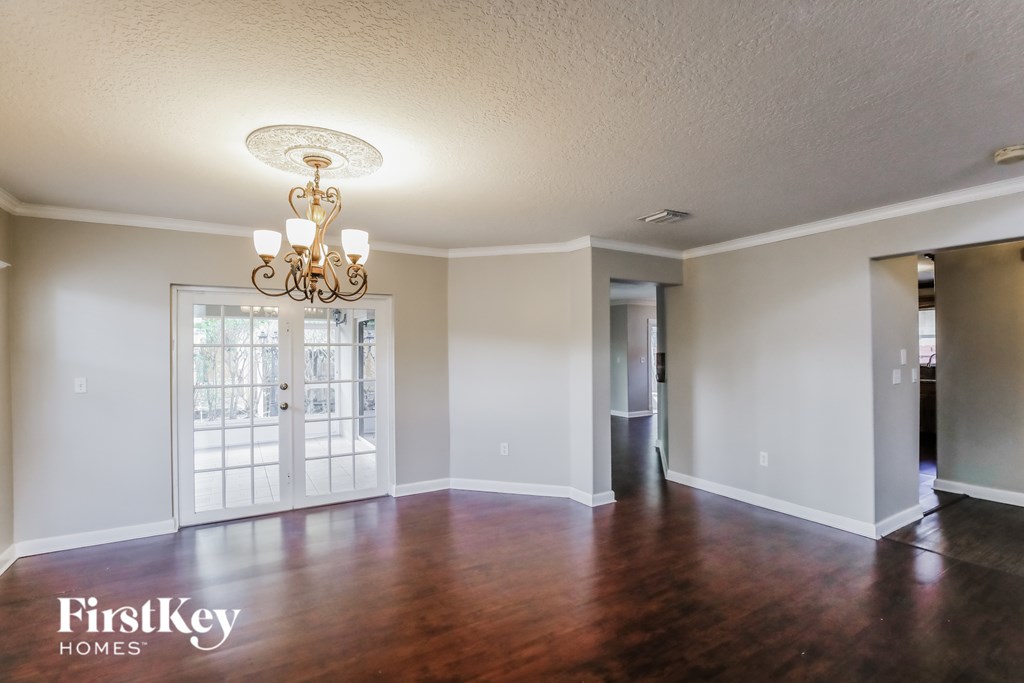 A room with wooden floors and a chandelier.