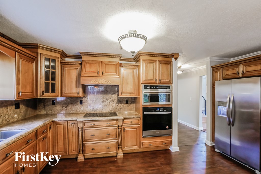 A kitchen with wooden cabinets and a stainless steel refrigerator.
